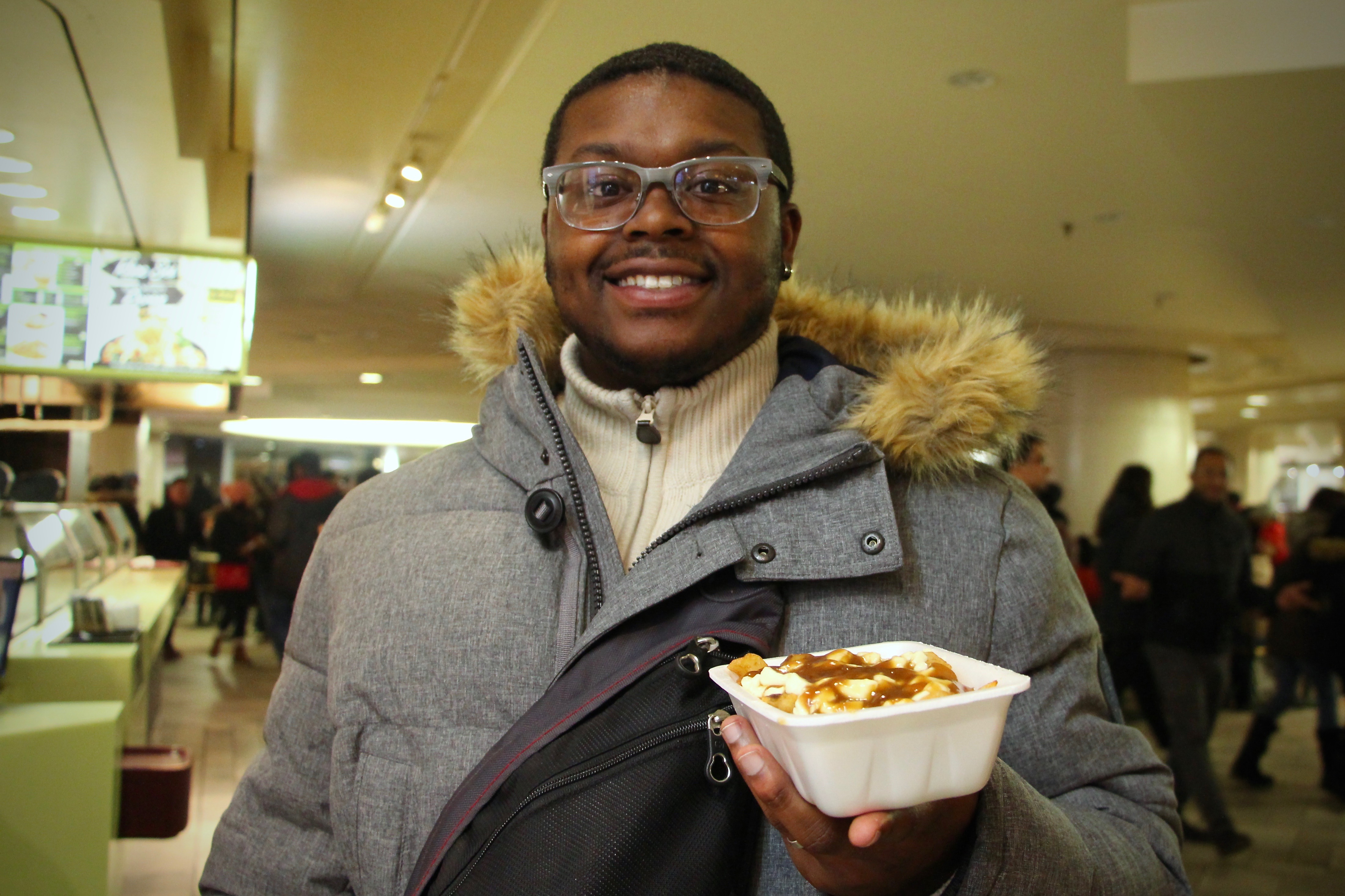 Jalen holding a serving of poutine.
