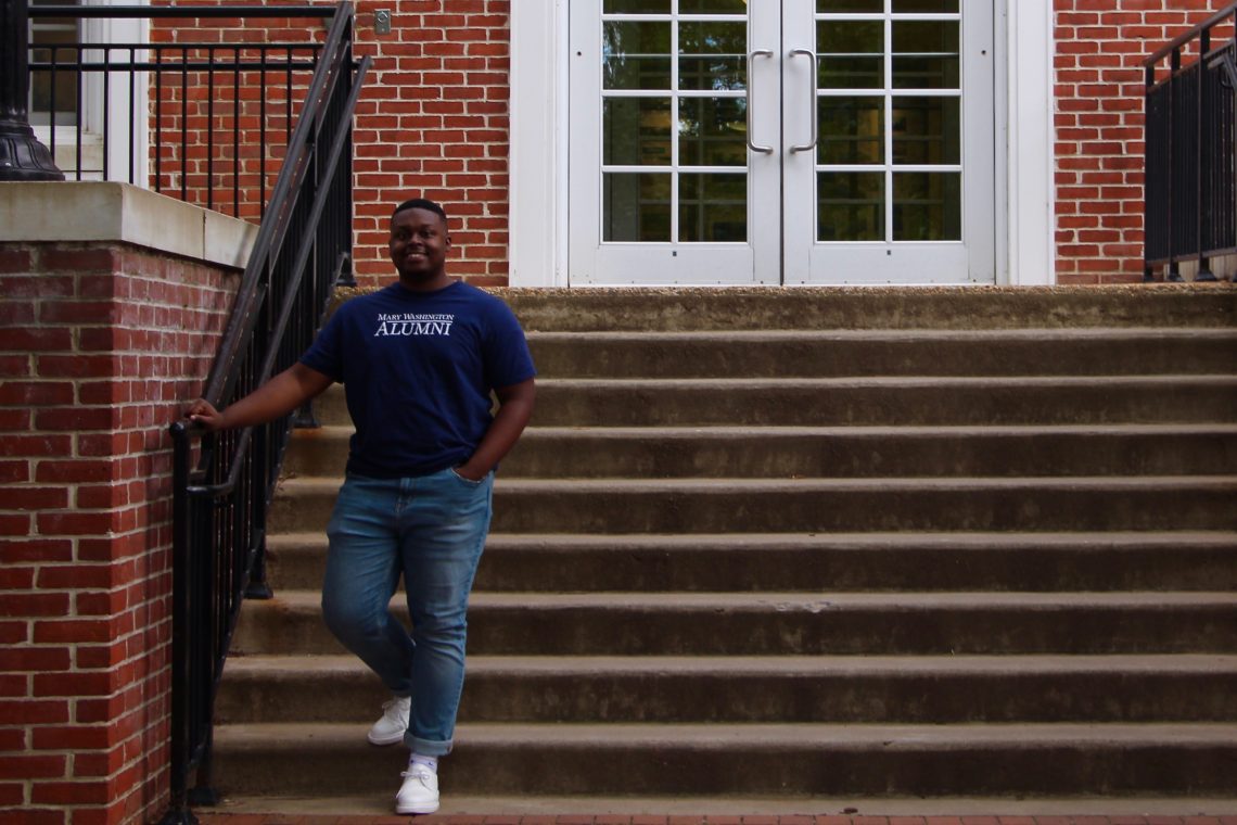 Jalen poses in front of Combs Hall at the University of Mary Washington.