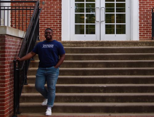 Jalen poses in front of Combs Hall at the University of Mary Washington.