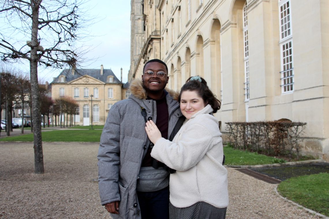 Jalen and Maria posing in front of a white building in Caen.