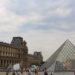 A view of the Louvre Pyramids with people in the area.