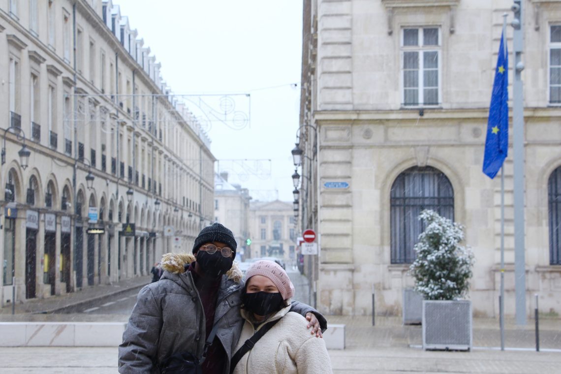 Jalen and Maria in front of a street in Reims, France. The European flag is behind them.
