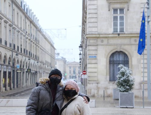 Jalen and Maria in front of a street in Reims, France. The European flag is behind them.