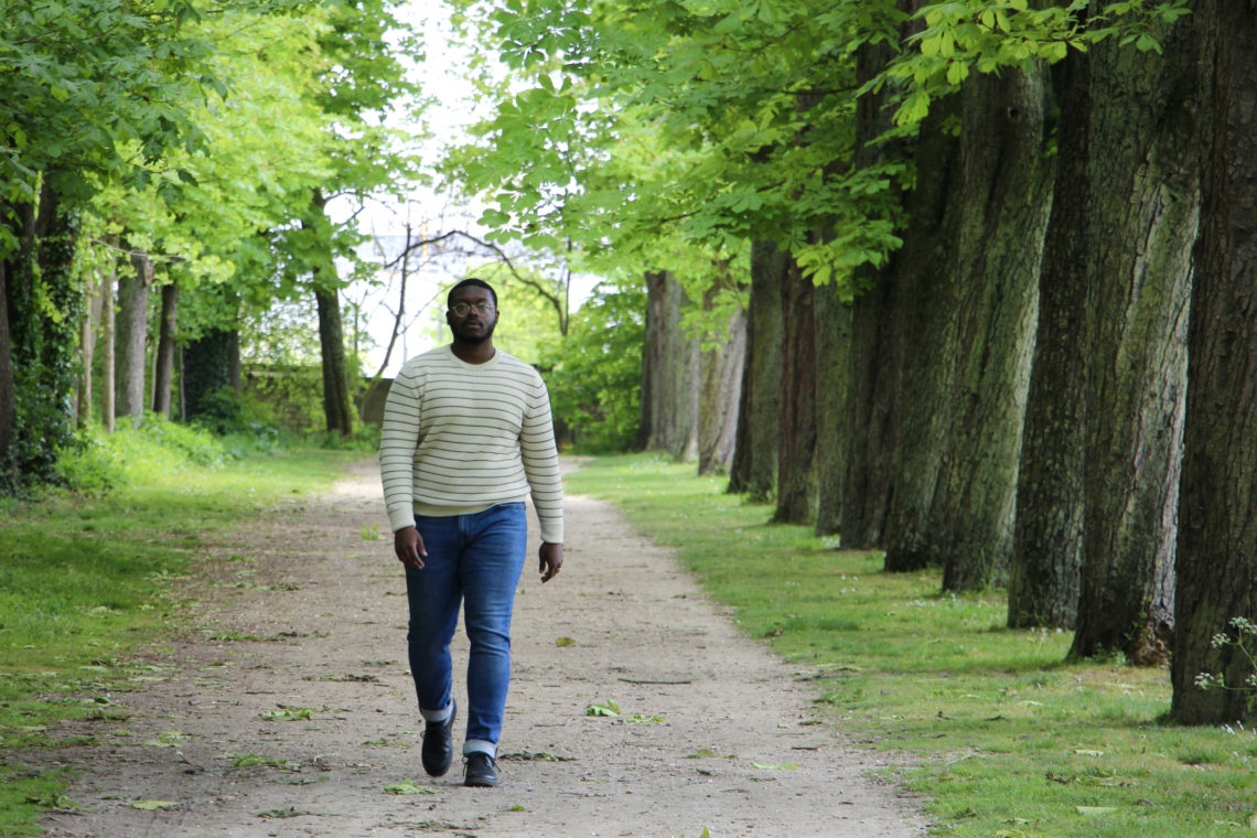 Jalen walks on a pathway lined by trees in the Parc du Champagne in Reims, France.