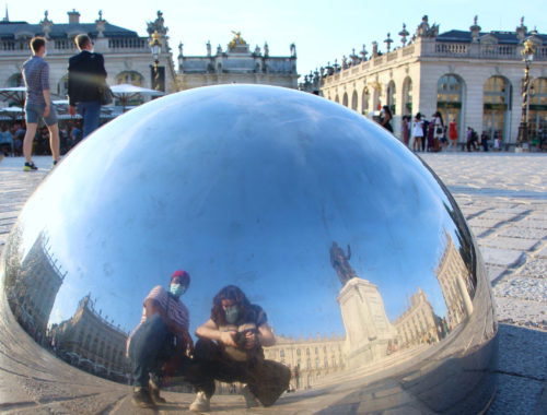 Jalen and Maria pose for a selfie in a reflective hemisphere in Place Stanislas in Nancy, France.