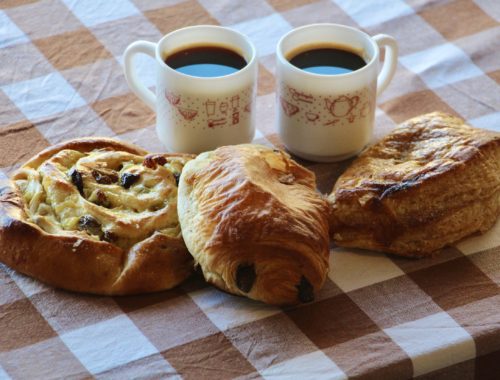 Two demitasse cups, a pain aux raisins, a pain au chocolat, and a chausson aux pommes.