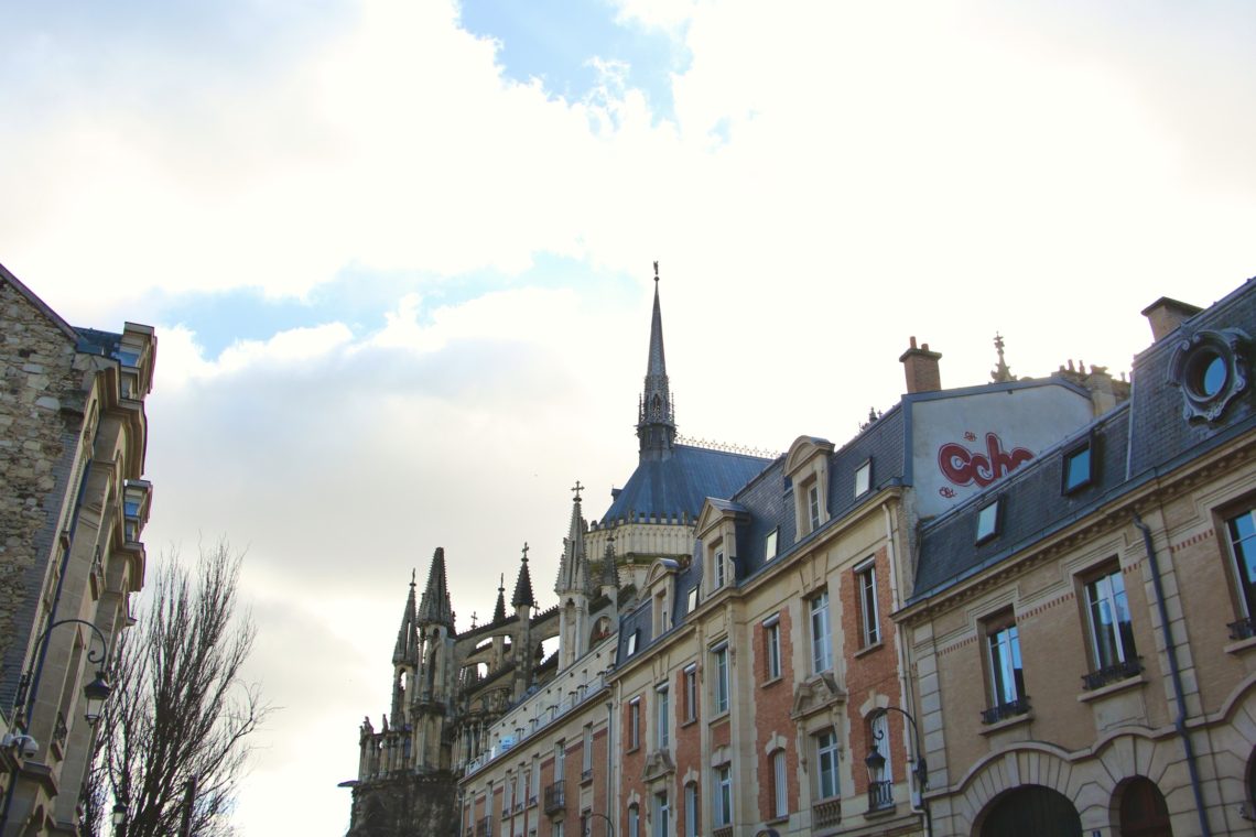 A street view of buildings and the Cathédrale de Reims.