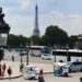 A view of the Eiffel Tower with tourists and vehicles in the streets of Paris, France.