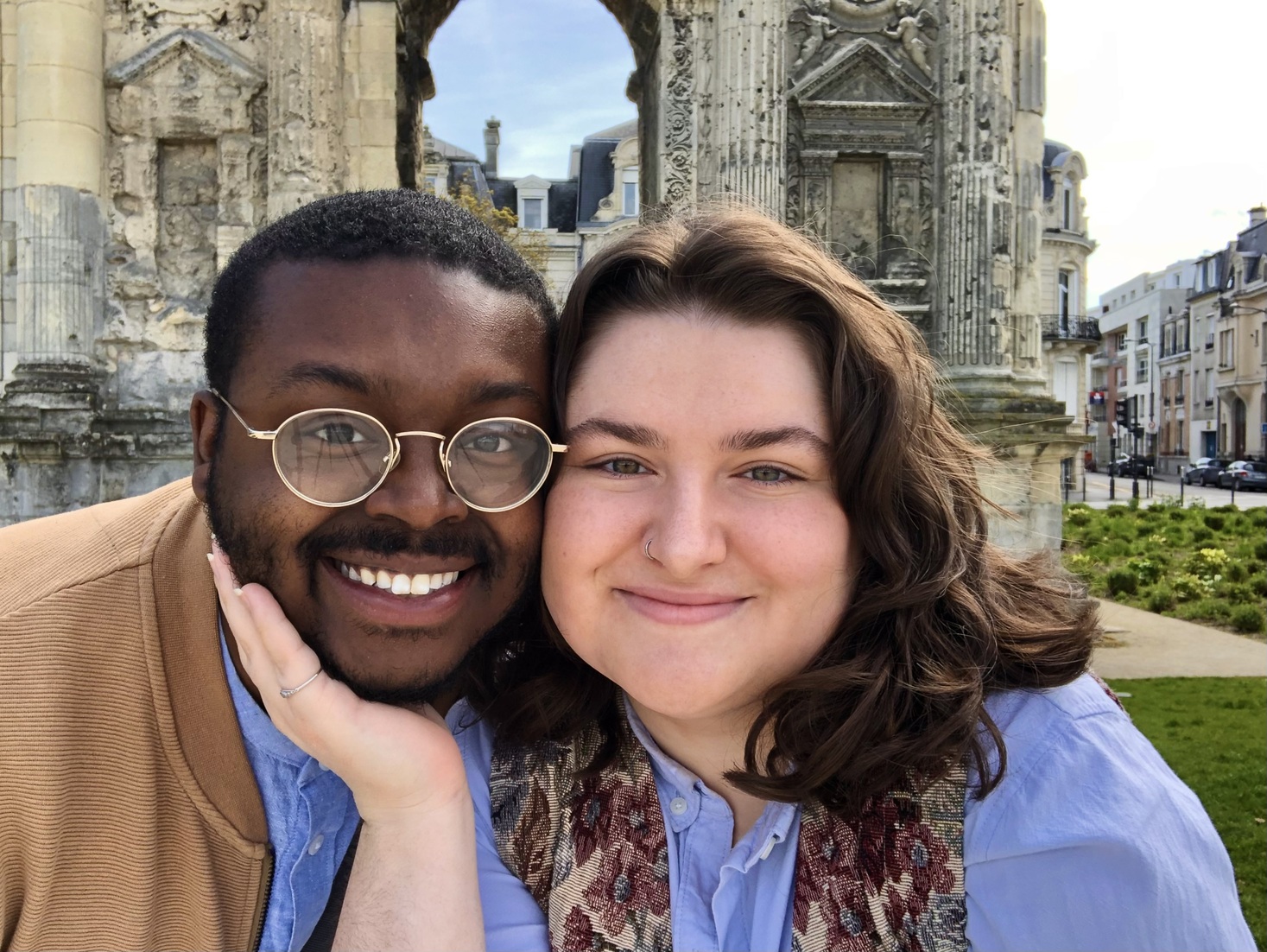 Jalen and Maria smile in front of the Porte de Mars in Reims, France.