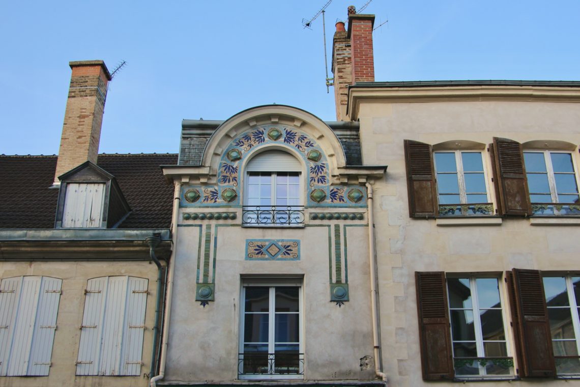 A close-up view of a building with ornate details in Reims, France.