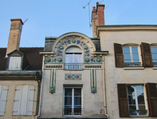 A close-up view of a building with ornate details in Reims, France.