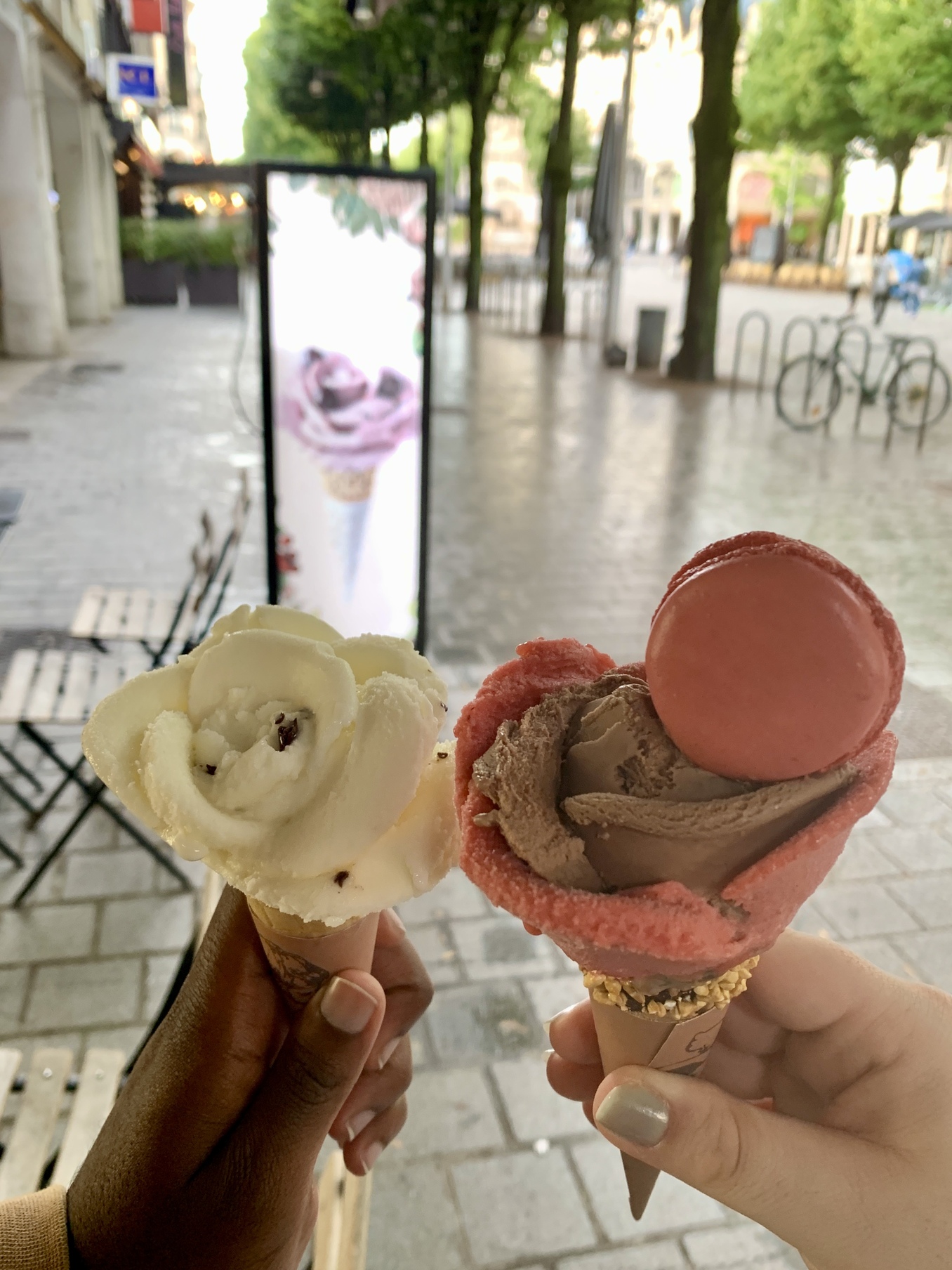 Maria and Jalen holding cones of flower-shaped gelato in Reims, France..