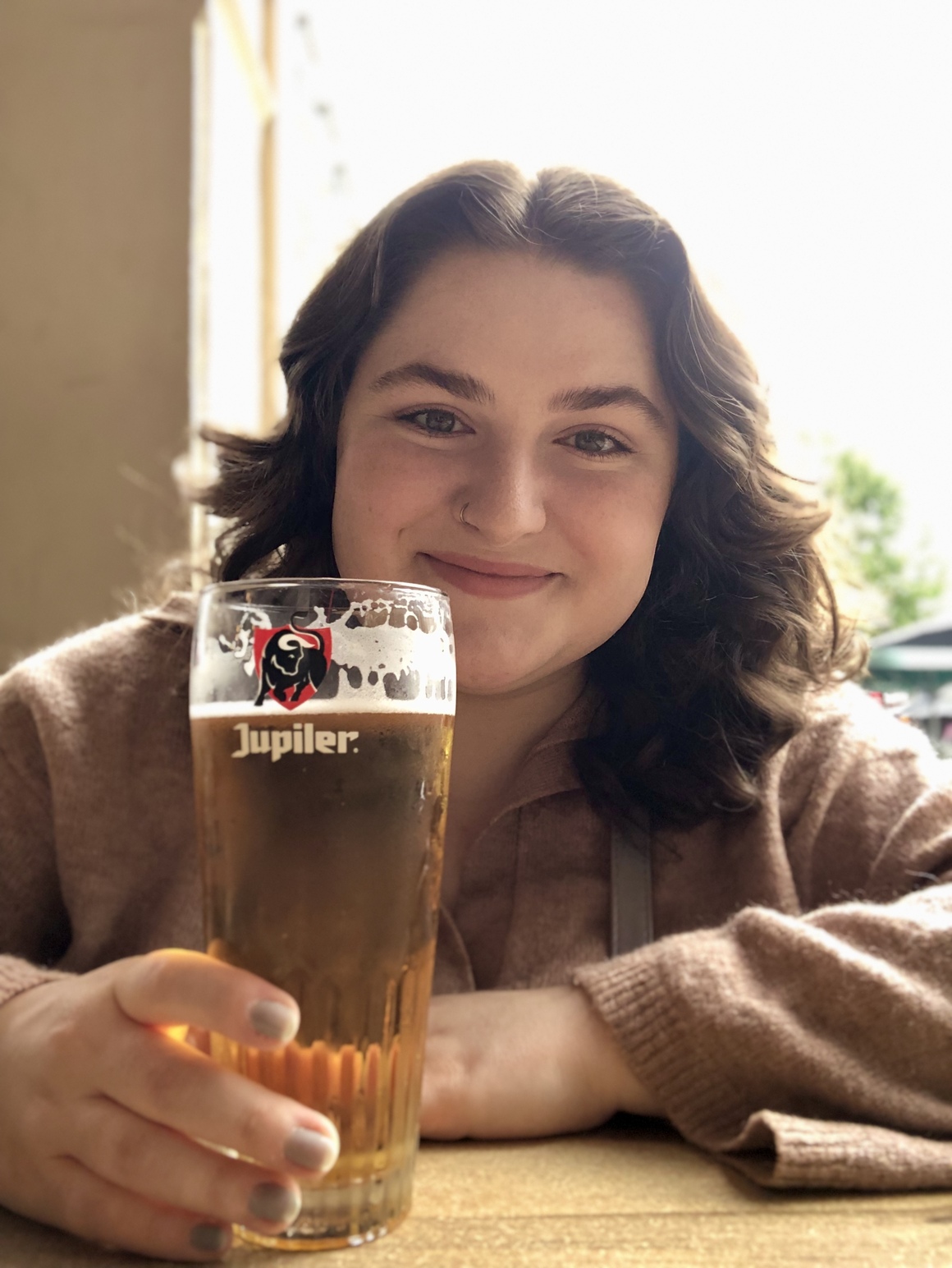 Maria smiling with a beer in Reims, France.