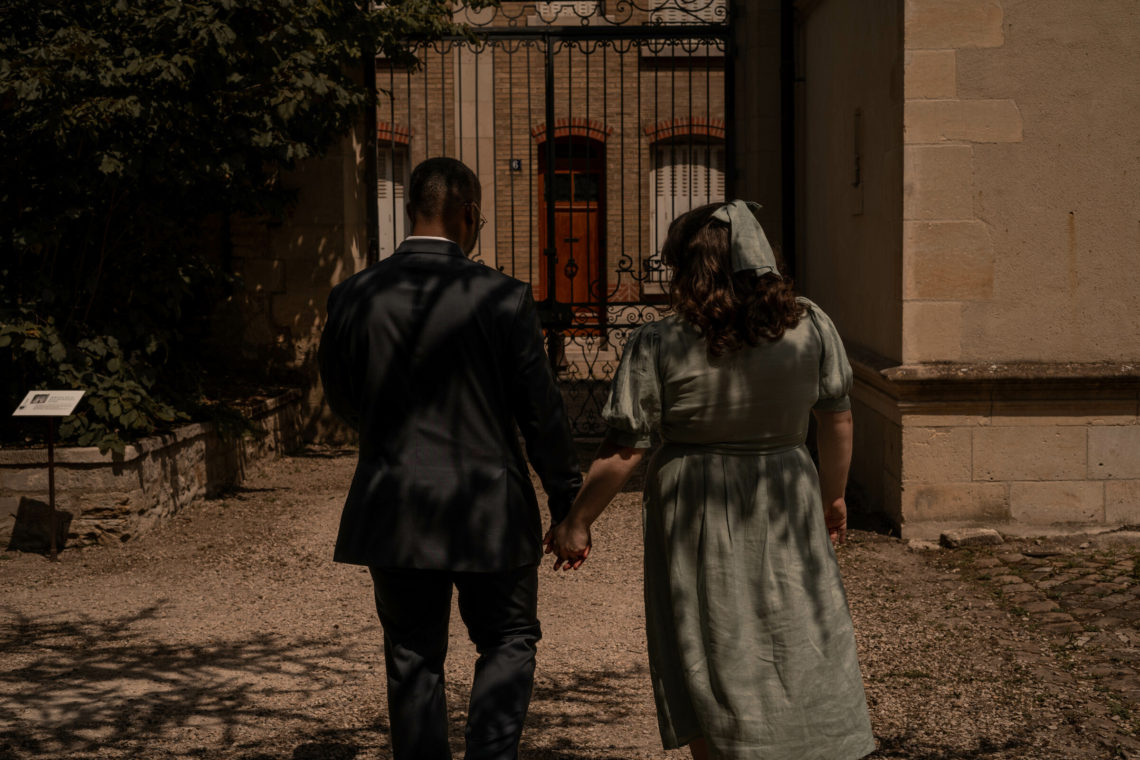 Jalen and Maria walk together in the Jardin du Musée Le Vergeur after their wedding.