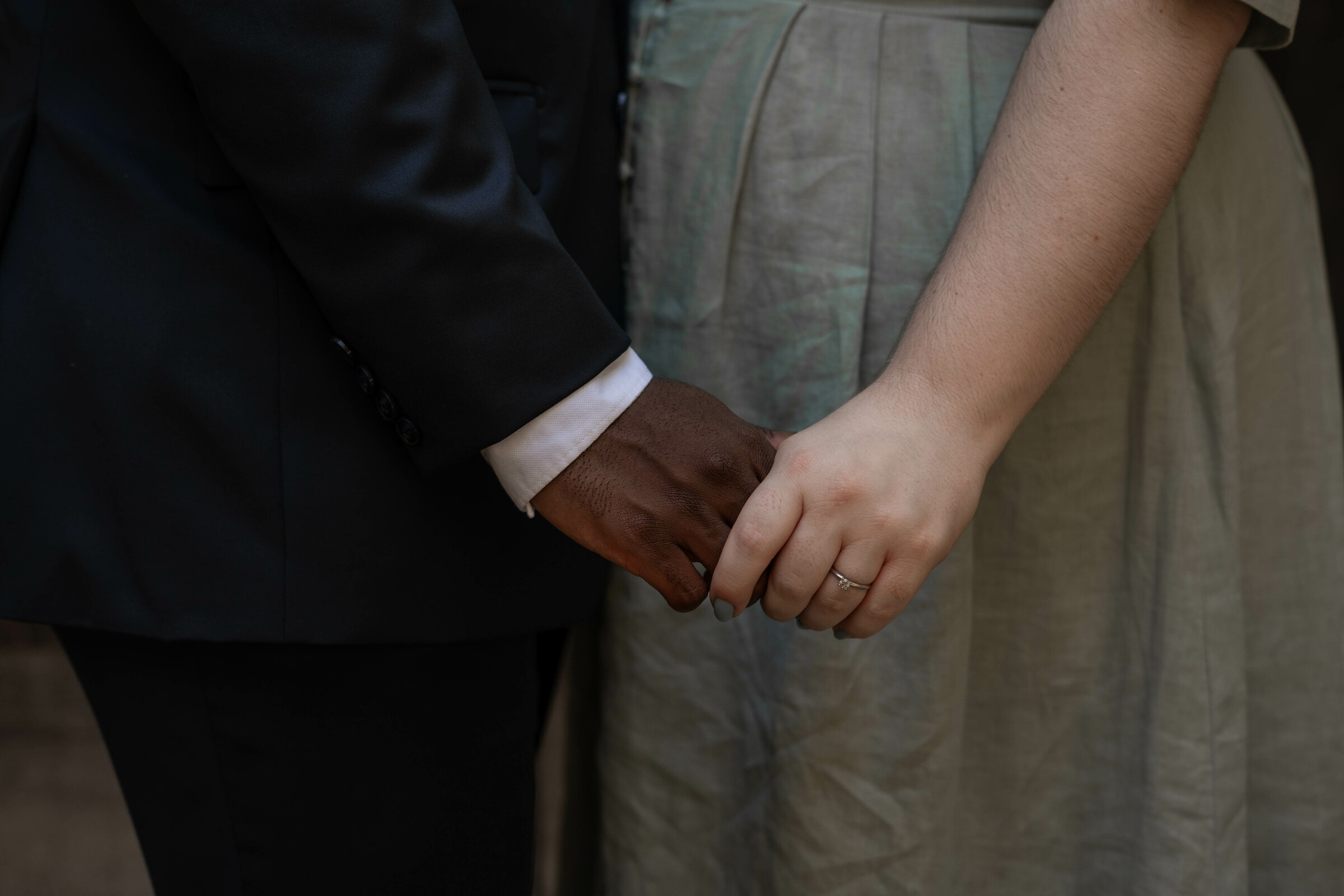 A close-up of Jalen and Maria holding hands after their wedding.