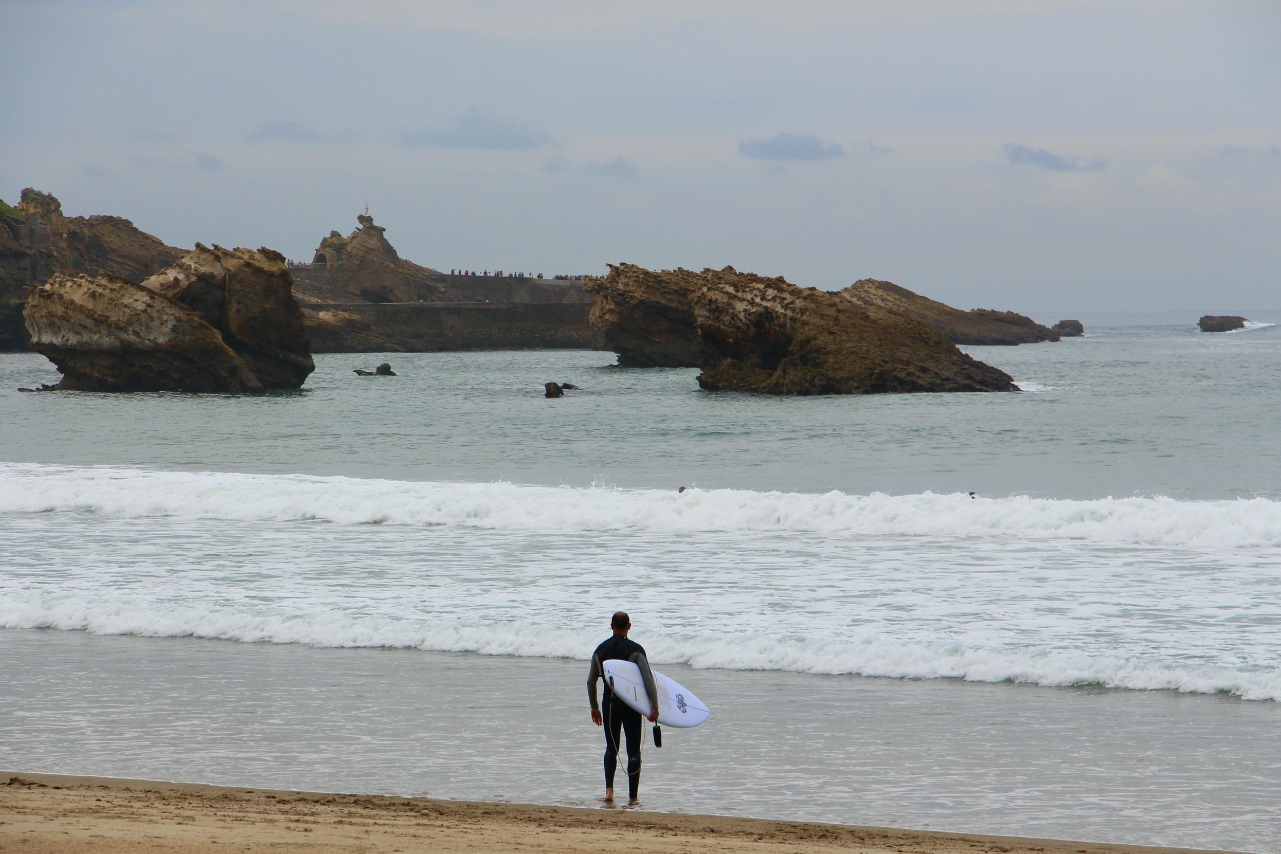 A surfer looking into the ocean in Biarritz, France.
