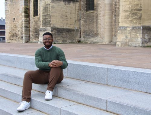 Jalen sitting on the steps of the Basilique Saint-Remi in Reims, France.