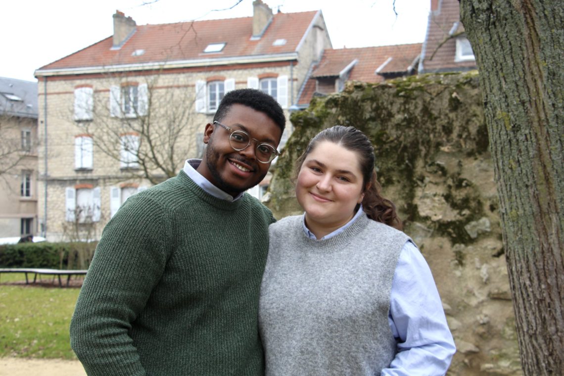 Jalen and Maria stand together and smile in the Parc Saint-Remi in Reims, France.