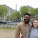 Jalen and Maria pose in front of Parisian buildings and the Eiffel Tower.