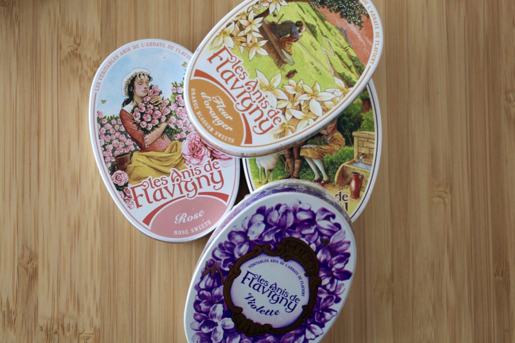 Four tins of Anis de Flavigny candies with floral illustrations on the lids.