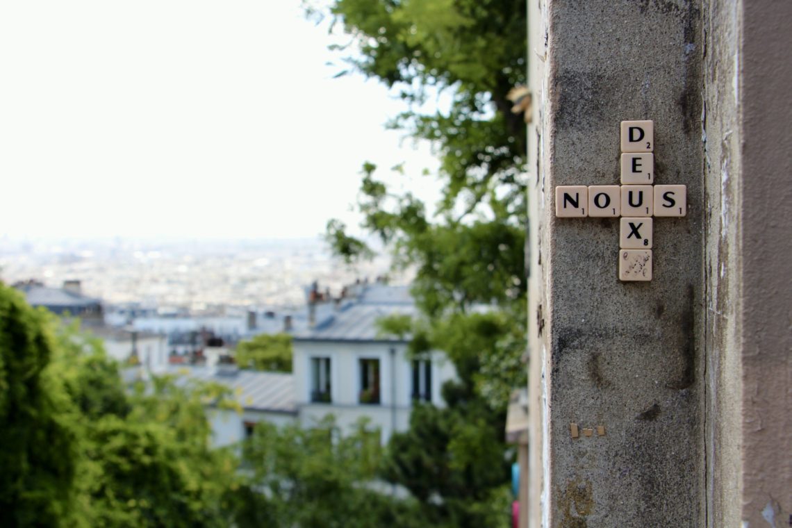 Scrabble street art that spells "nous deux" in Montmartre, Paris, France.